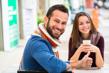 Man and woman drinking tea or coffee. Picnic. Drink warm in cool weather. Happy couple with coffee cups in autumn park. Love story concept
