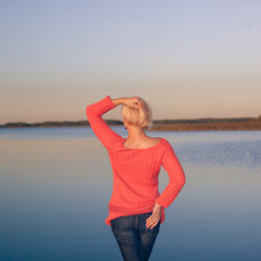 Back side view of Traveler girl watching to lake. Back of the girl in front of the lake