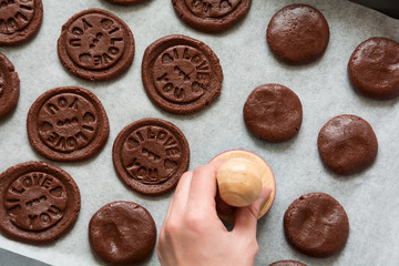 Preparing chocolate cookies with pressed text 'I love you'