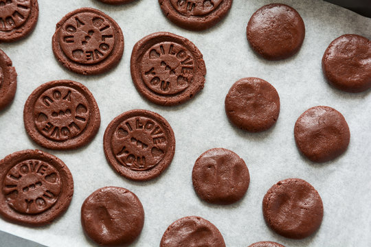 Preparing chocolate cookies with pressed text 'I love you'