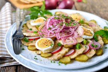 Bayerischer Knödelsalat aus geschnittenen Semmelknödel und weiteren Zutaten sauer mit Apfelessig und Öl angemacht