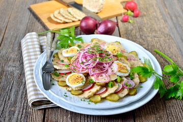 Bayerischer Knödelsalat aus geschnittenen Semmelknödel und weiteren Zutaten sauer mit Apfelessig und Öl angemacht