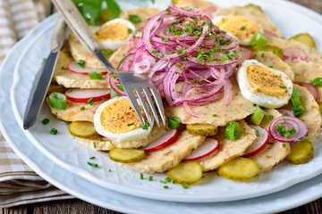 Bayerischer Knödelsalat aus geschnittenen Semmelknödel und weiteren Zutaten sauer mit Apfelessig und Öl angemacht