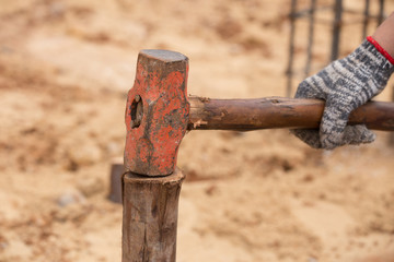 Worker hammering eucalyptus pointed