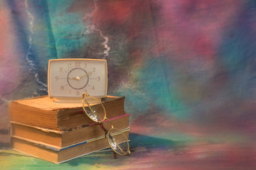 Vintage book, glasses and watches on the background of a wooden
