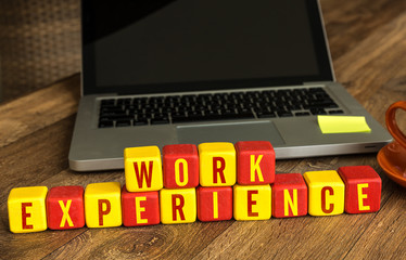 Work Experience written on a wooden cube in a office desk