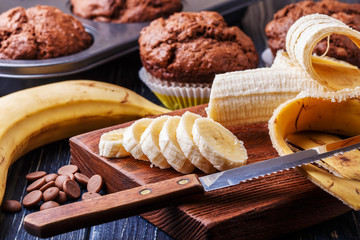 Chocolate muffins with banana on dark background.