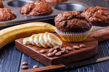Chocolate muffins with banana on dark background.