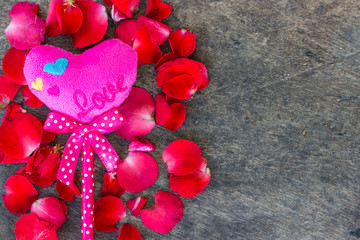 Rose Petals and pink heartson a wooden background