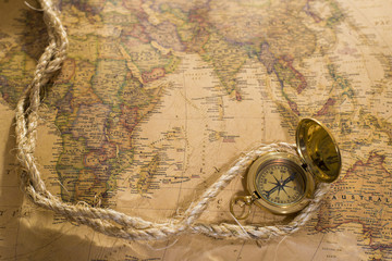 old compass and rope on vintage map