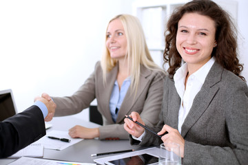 A group of business people at a meeting on the background of office. Business handshake