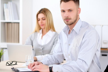 Obraz premium Successful businesspeople working at meeting in office. Businessman looking at camera. Start up business concept.