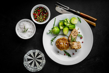 Fried pork meatballs served with brussels sprouts and arugula