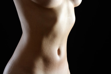 Fototapeta premium Schlanke Frau nackt zeigt Brust und Bauch für Aktfoto