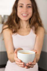 Obraz na płótnie Canvas Woman showing a cup of coffee