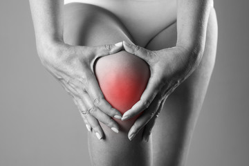 Pain in the knee. Pain in the human body on a gray background