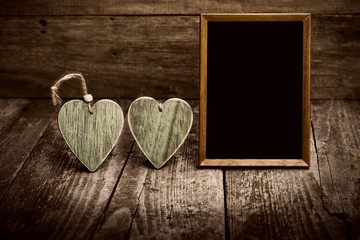 Two Green Wooden Hearts With Blackboard On Wooden Board. Love Concept In Old Style.