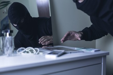 Masked intruder during robbery - obrazy, fototapety, plakaty