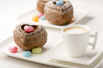 Chocolate muffins in the shape of heart on the white plate.