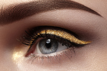 Beautiful macro shot of female eye with ceremonial makeup. Perfect shape of eyebrows, eyeliner and...