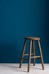 Wooden Stool on a Wooden Floor Over Over Blue Backdrop