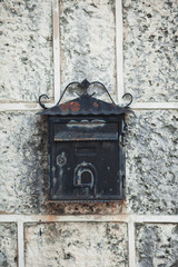 old black iron mailbox hanging on the wall