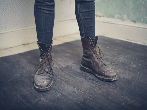 Person wearing boots standing in empty room