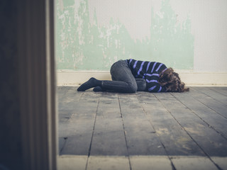 Sad young woman lying on floor