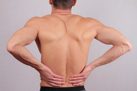 Man with  back pain. Man rubbing his painful back close up. Pain relief concept