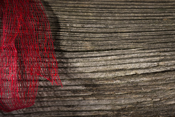 Fototapeta na wymiar Red ribbon over wooden background. Space for text