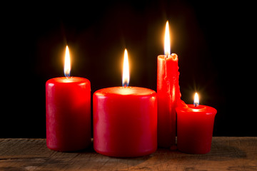 Red candle on wooden plank