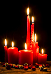 Red candle on wooden plank
