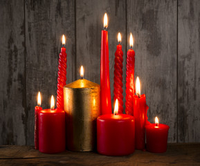 Red candle on wooden background