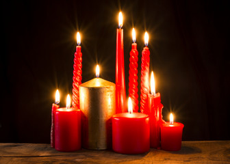 Red candle on wooden plank.