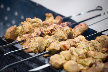 Grilling marinated shashlik on a grill. Shashlik is a form of Shish kebab popular in Eastern, Central Europe and other places. Shashlyk (meaning skewered meat) was originally made of lamb.