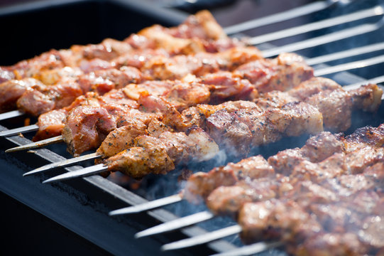 Grilling marinated shashlik on a grill. Shashlik is a form of Shish kebab popular in Eastern, Central Europe and other places. Shashlyk (meaning skewered meat) was originally made of lamb.