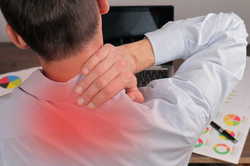 Man with back pain. Business man rubbing his painful neck close up