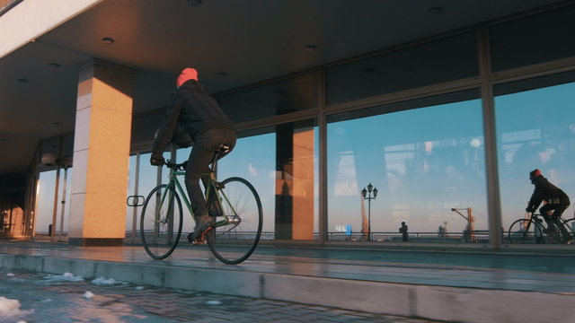 Guy riding fixed gear bike on background of the port, 4k