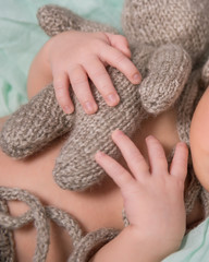 newborn baby sleeping with knitted toy