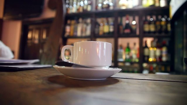 cup of coffee with sugar is at  bar in a cafe