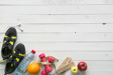fitness items on wooden planks background with text space