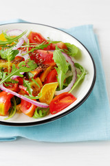 tomato salad with arugula in vintage plate