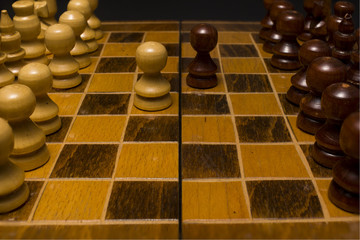 Light and dark wooden chess pieces on chess table. High resolution image.