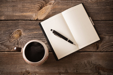 notebook with pen and coffee on old wooden table - obrazy, fototapety, plakaty