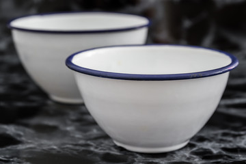 Big White Vintage Enamel Bowls on Black Marble Background