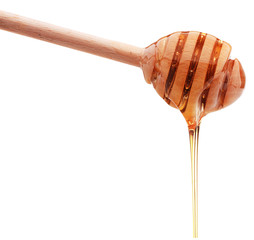 Honey dripping from a wooden honey dipper isolated on white back