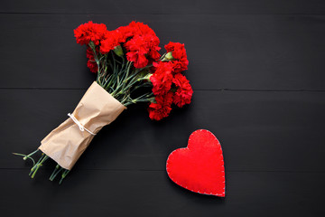 Still life of red carnations and handmade heart