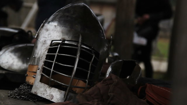 Medieval warriors putting on battle equipment, preparing for military campaign