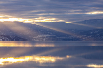 Obraz premium Rays of Sunset on Mountain Lake in Winter