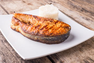 Roasted grill salmon steak with rice on white plate. Restaurant fish menu background